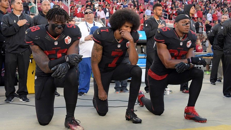 Colin Kaepernick kneeling down with his then 49ers teammates.